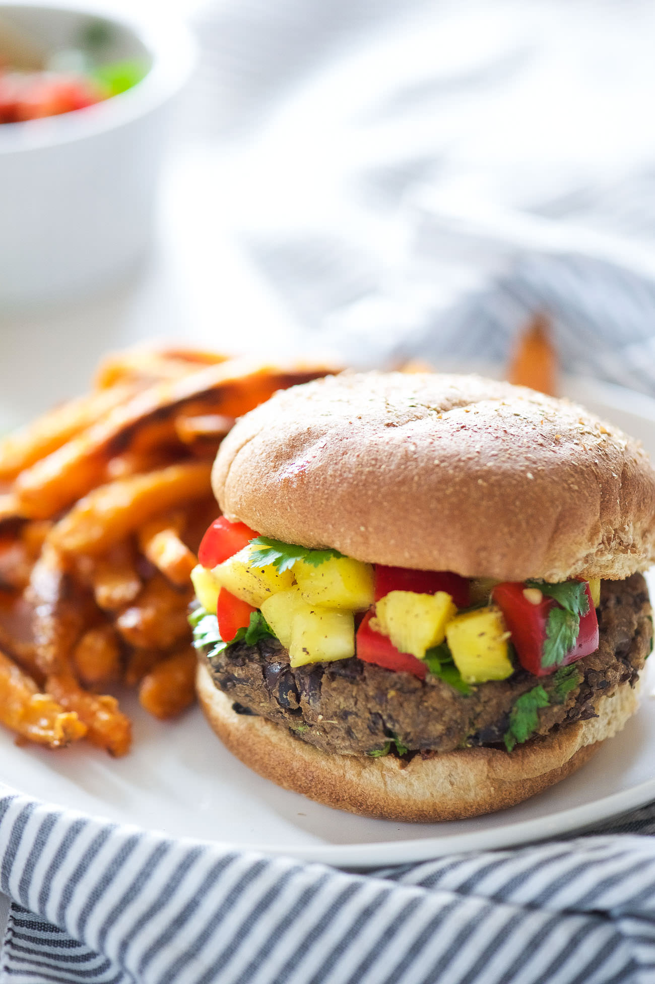 Take a bite out of these 20 Minute, homemade black bean burgers that come together with pantry items and topped with a sweet, pineapple salsa! 